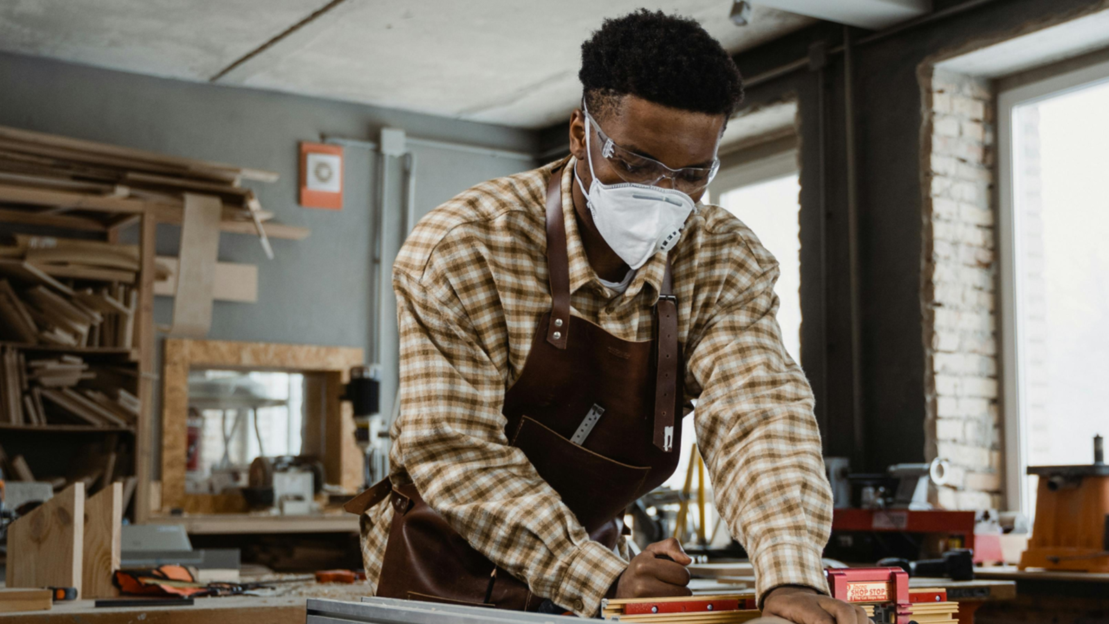 Mann mit Maske arbeite an der Säge