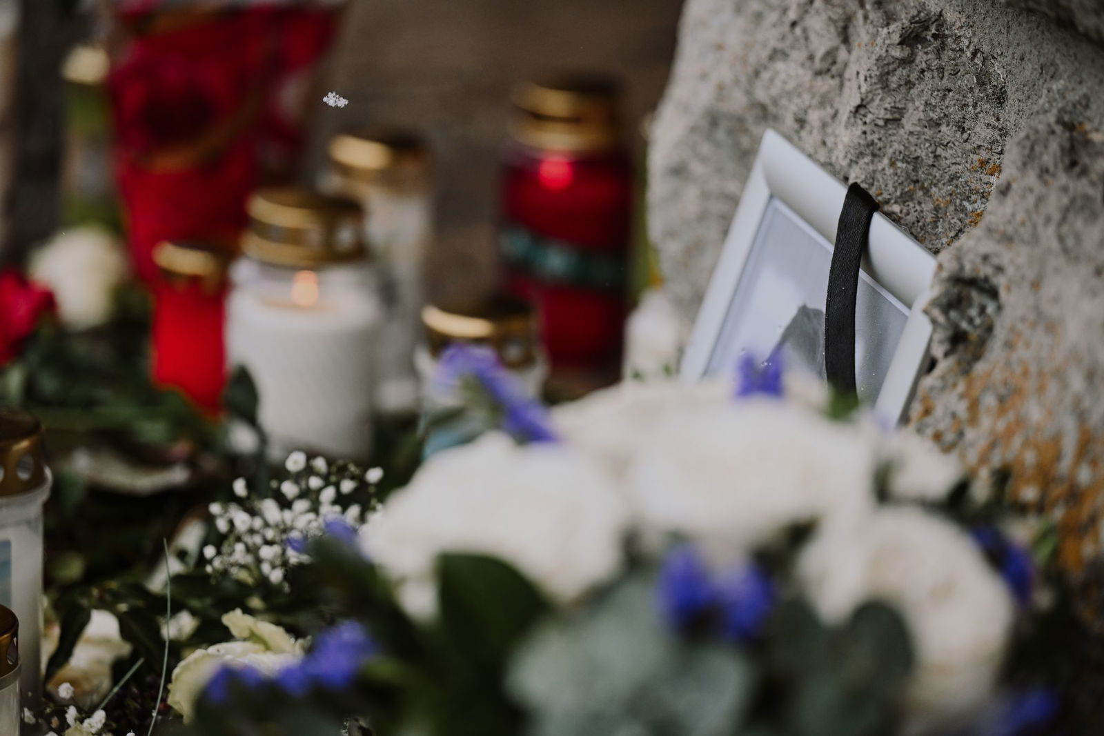 Vor dem Rathaus haben viele Menschen Kerzen und Blumen abgelegt.