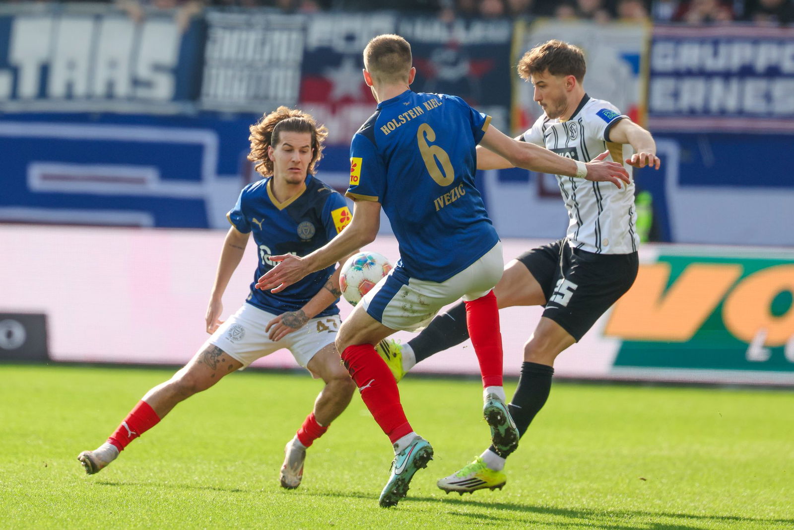 Elversbergs Lukas Petkov (r) im Duell mit den Kielern John Tolkin (l) und Marko Ivezic.