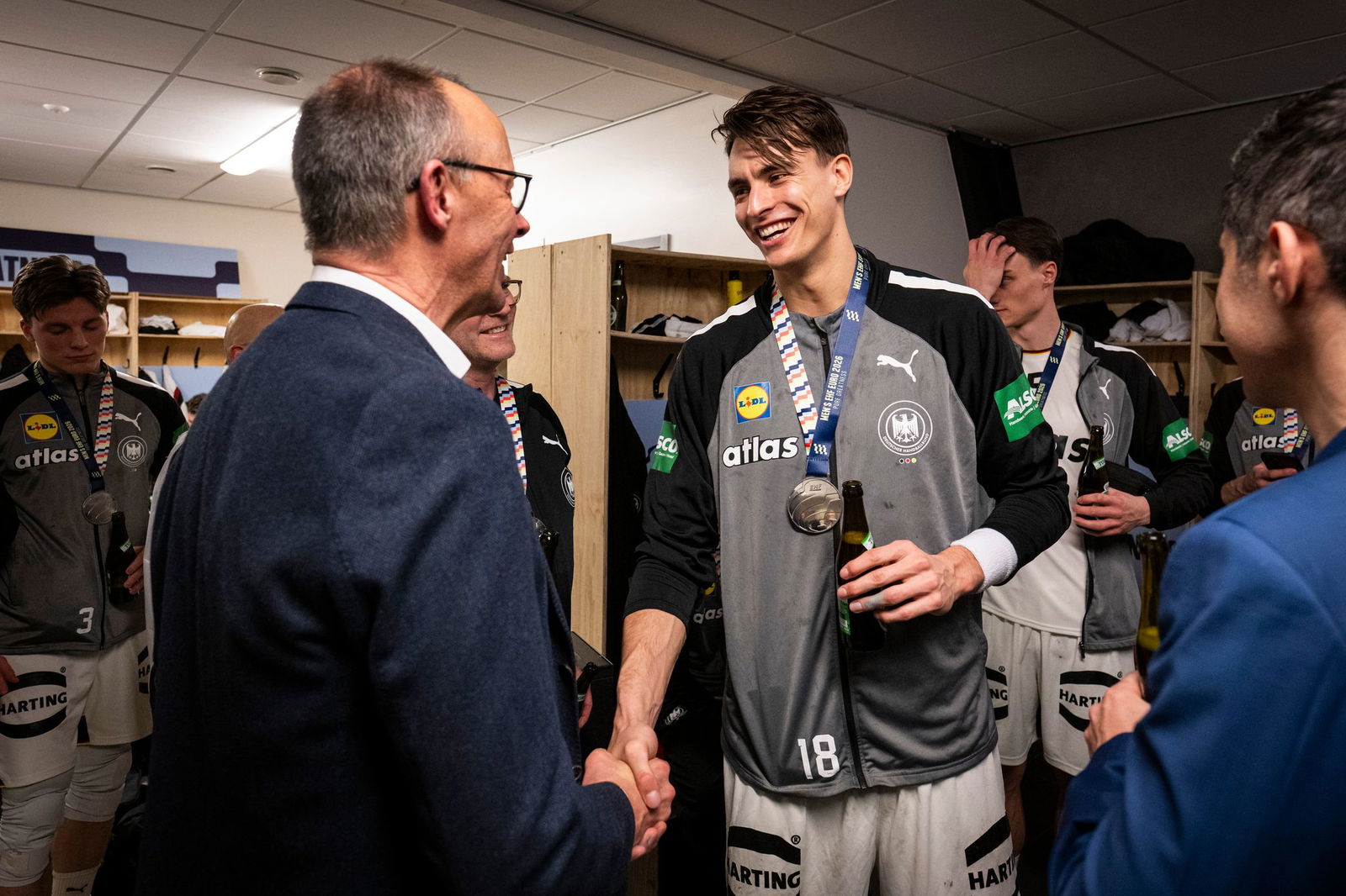 Bundeskanzler Friedrich Merz gratuliert Deutschlands Handballern in der Kabine. 