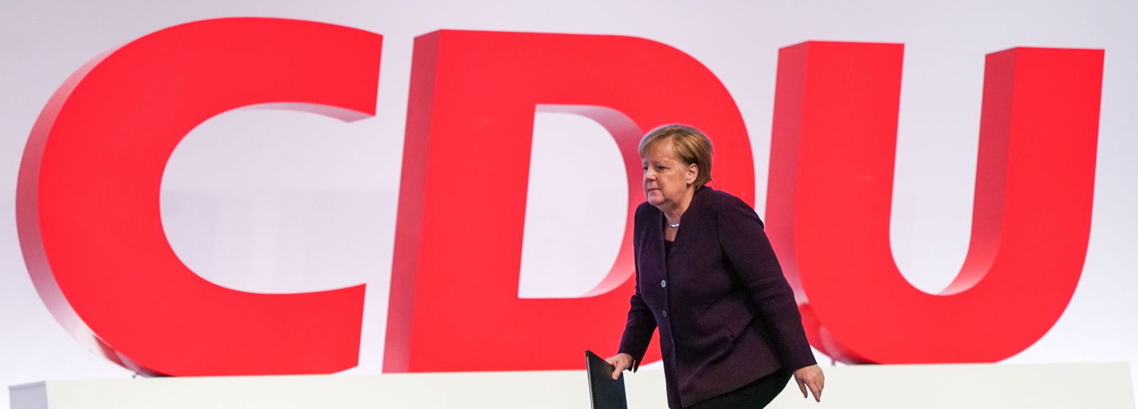 Sie kehrt nach langer Abwesenheit zurück. Angela Merkel wird in der ersten Reihe sitzen, wenn Merz redet.