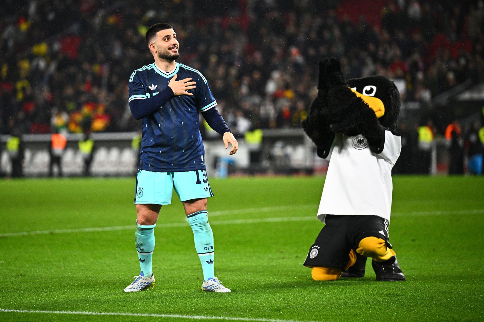 Der Matchwinner: Deniz Undav jubelt nach dem Spiel neben dem DFB-Maskottchen.