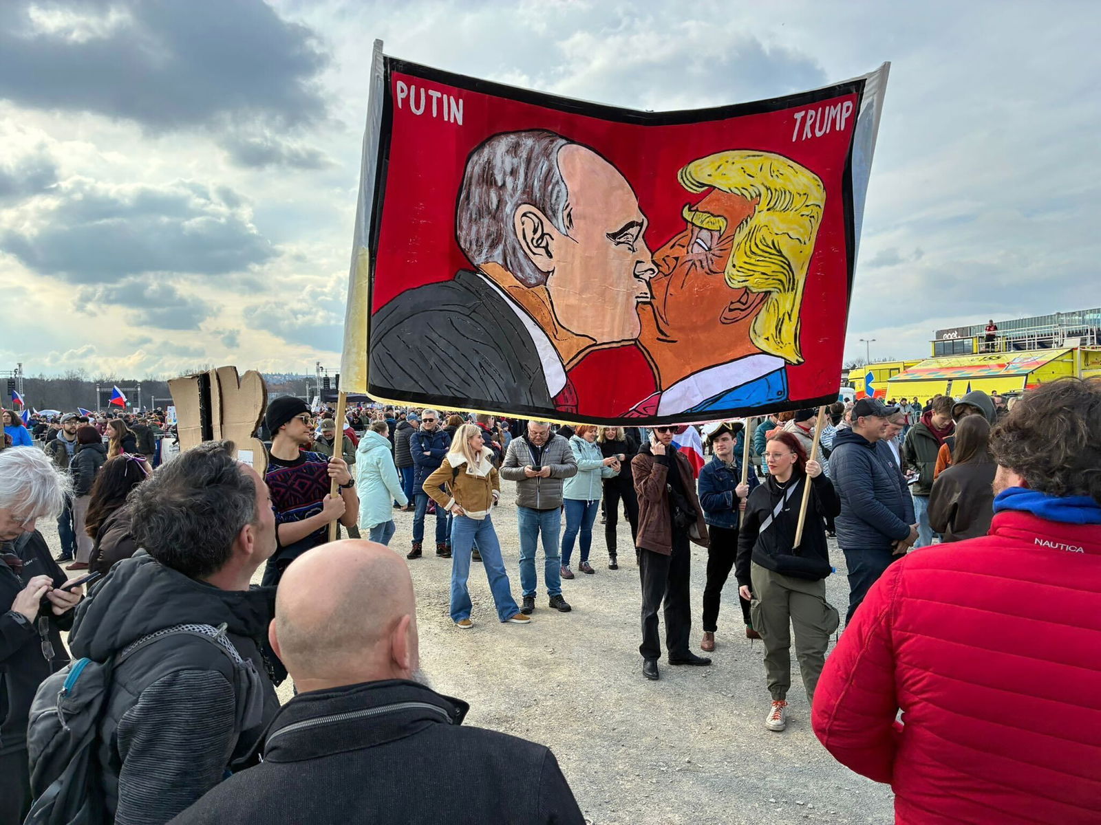 Demonstranten halten bei einer Kundgebung des Bündnisses «Eine Million Augenblicke für Demokratie» ein Banner, auf dem sich stilisiert US-Präsident Trump und Russlands Präsident Putin küssen.