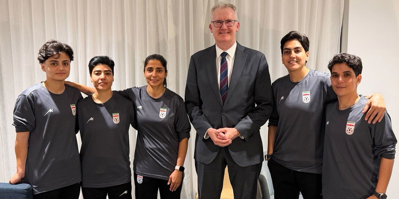 Australiens Innenminister Tony Burke (M) mit Spielerinnen des Irans.