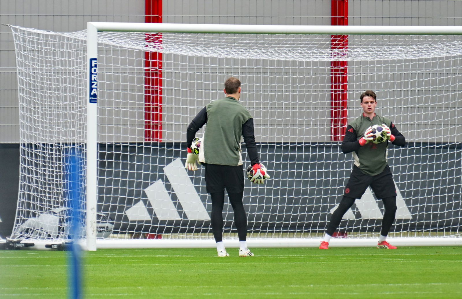 Jonas Urbig beim Abschlusstraining in Aktion, links Manuel Neuer.