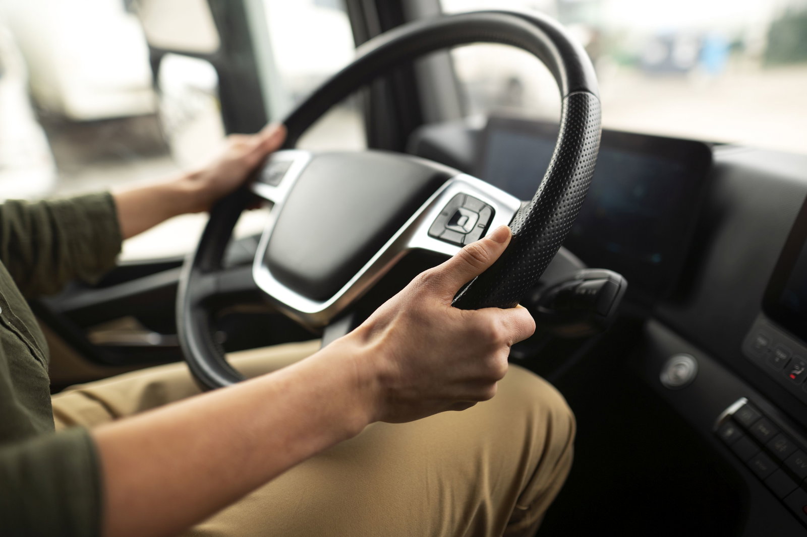 Busfahrer hält Lenkrad in den Händen