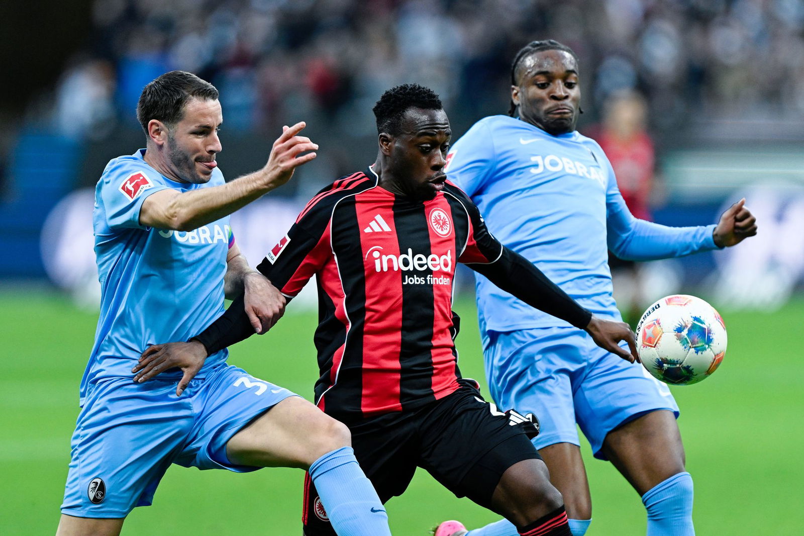 Der SC Freiburg um Christian Günter (l) und Bruno Ogbus (r) sowie Eintracht Frankfurt mit Arnaud Kalimuendo (M) lieferten sich ein umkämpftes Duell.