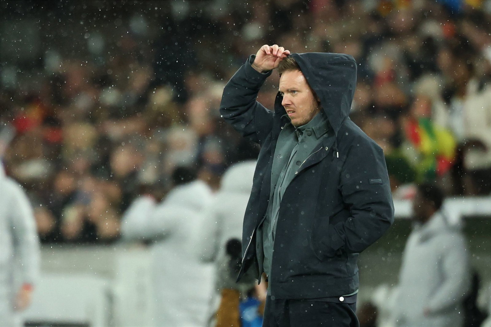 Julian Nagelsmann zieht sich im Regen eine Kapuze über den Kopf.