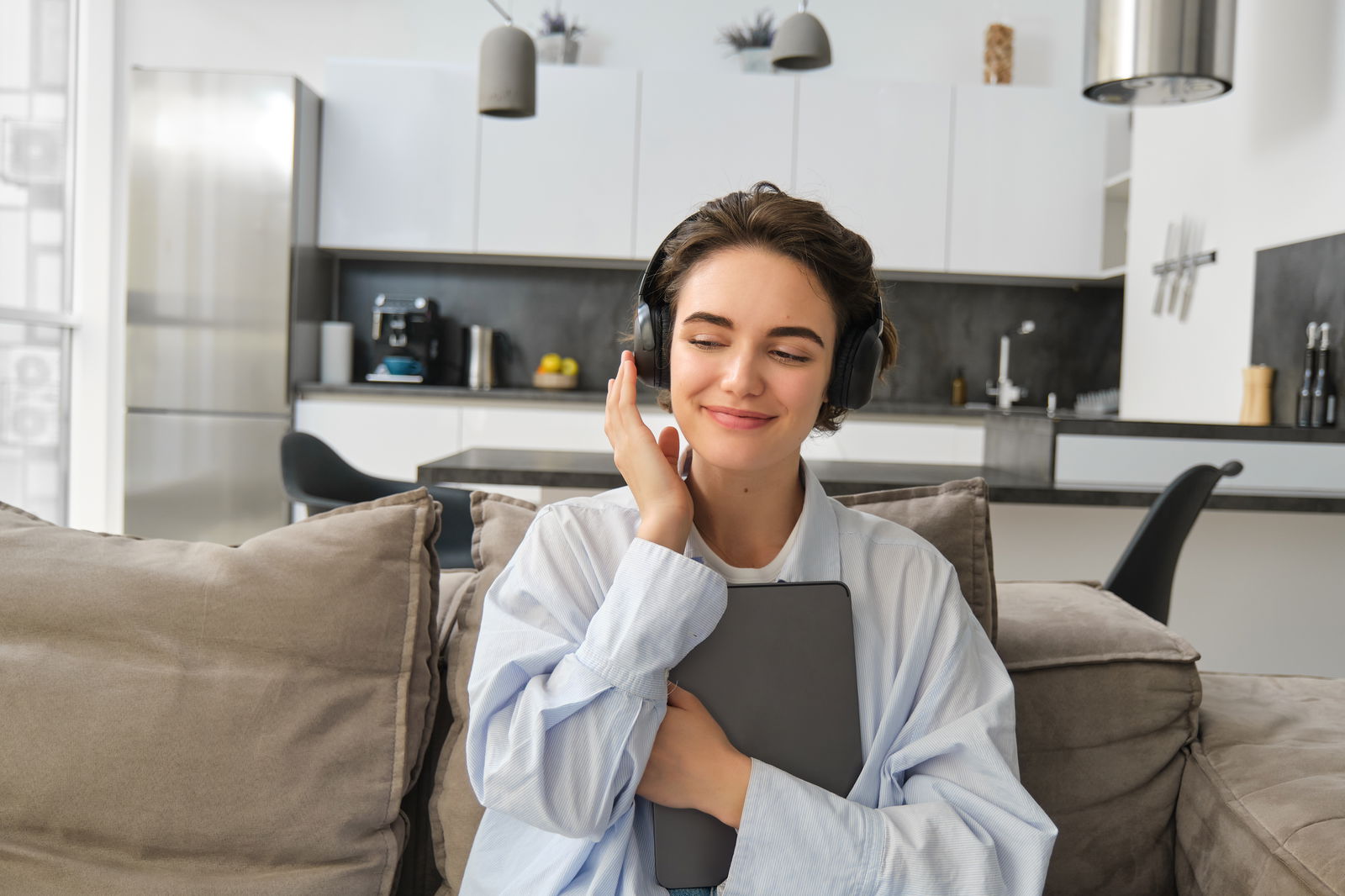 Frau mit Kopfhörern auf der Couch