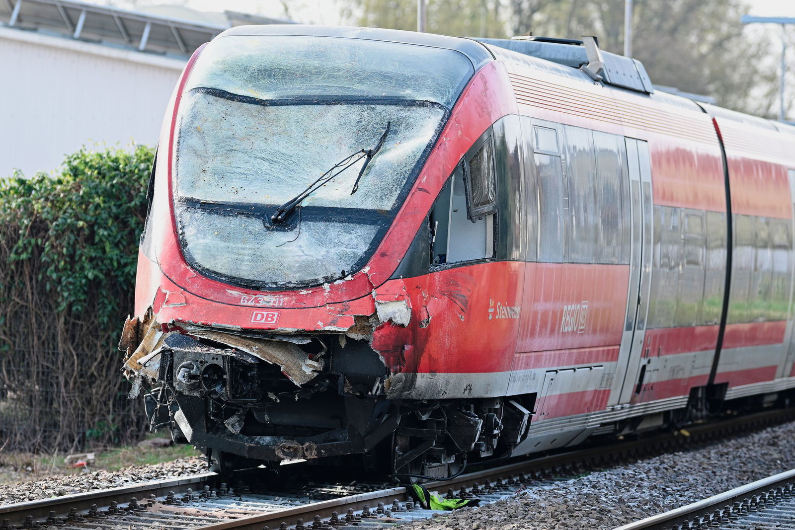 Der Regionalzug mit beschädigter Front steht am Bahnhof auf den Gleisen. 