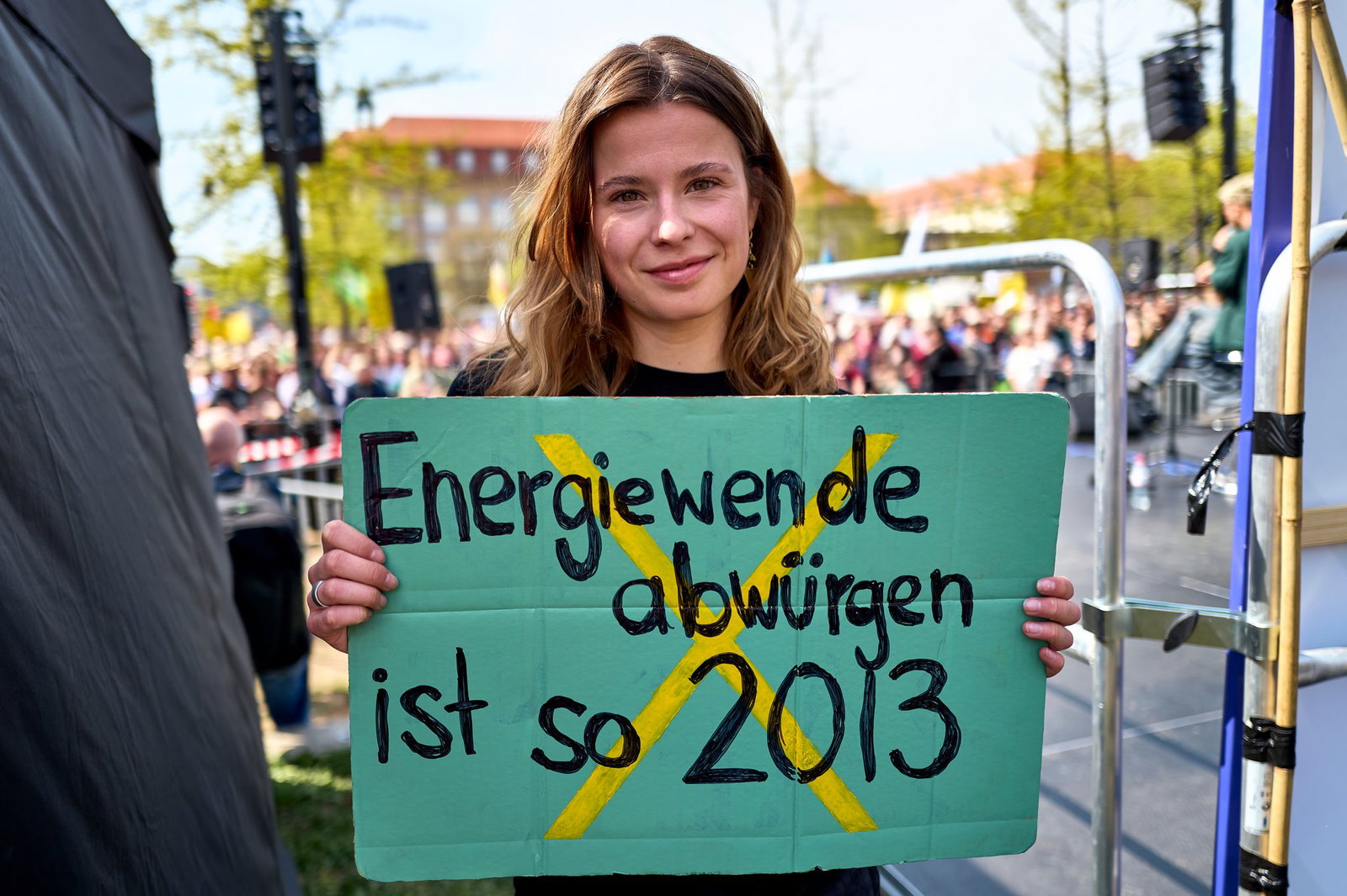 Luisa Neubauer hält ein Schild mit der Aufschrift «Energiewende abwürgen ist so 2013» in der Hand. 