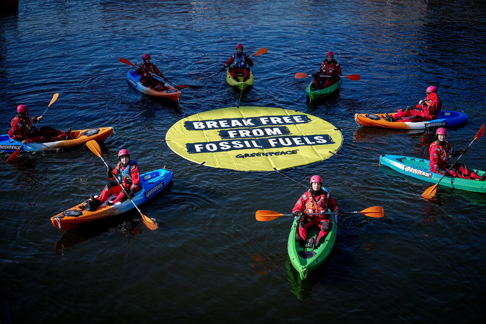 Greenpeace fordert bei einer Aktion am Veranstaltungsort die Abkehr von fossilen Energien.