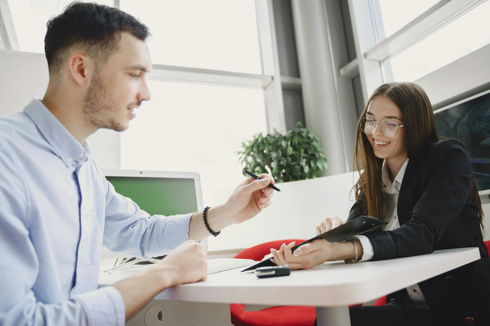 Bankkauffrau sitzt in einem Beratungsgespräch mit einem Kunden
