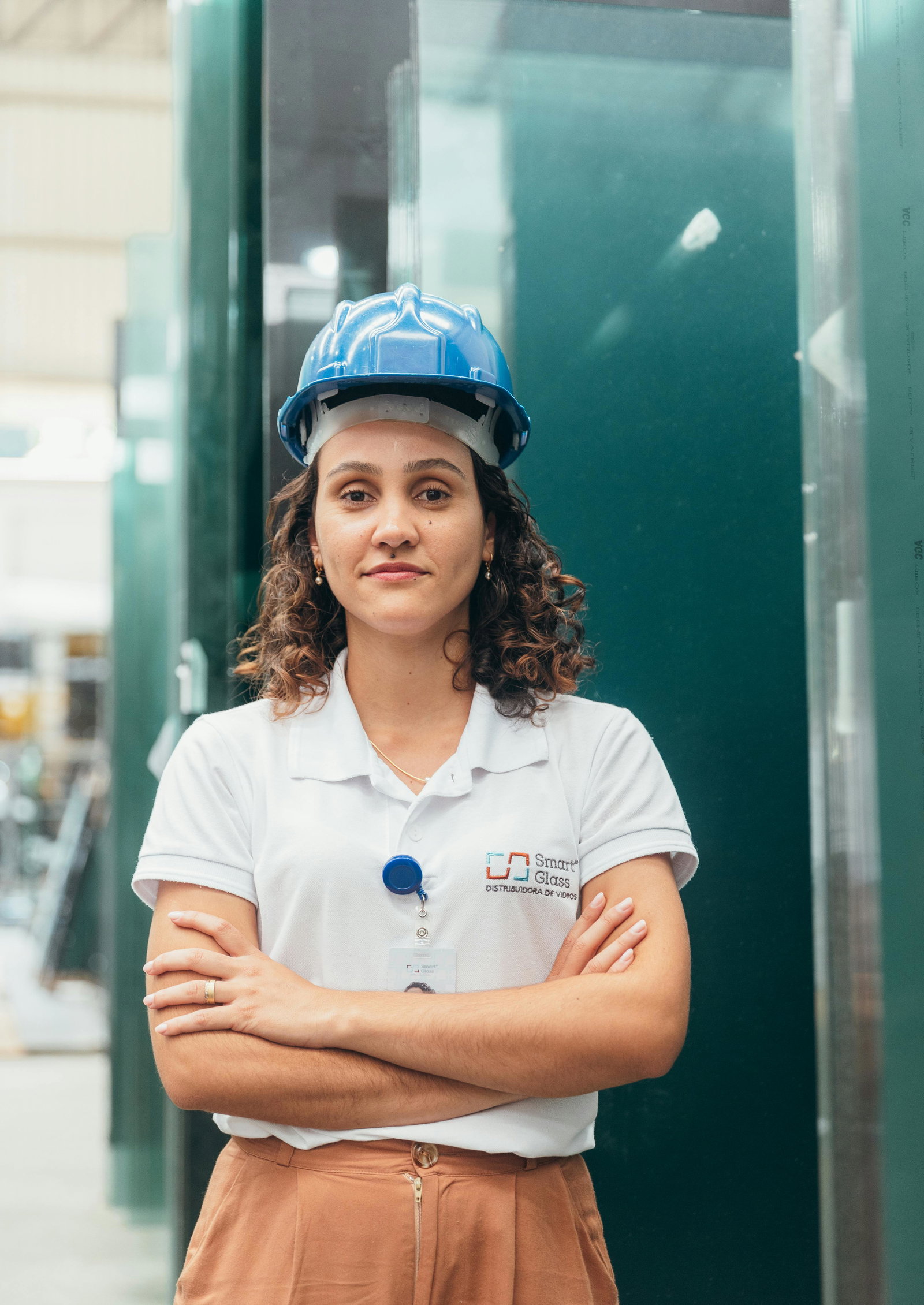 Industriekauffrau mit blauem Helm auf schaut in die Kamera