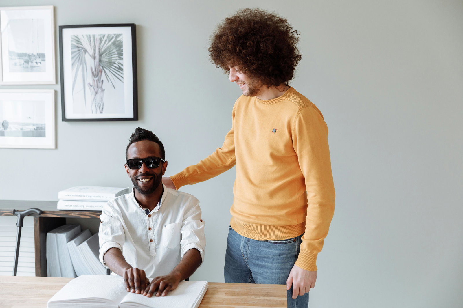 Sozialisierten hilft Blindem beim Lesen mit Blindenschrift