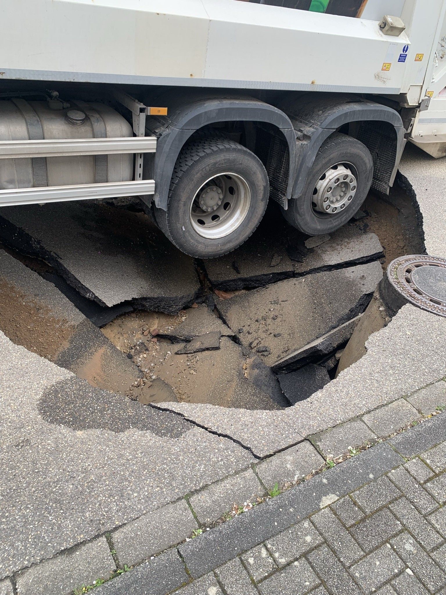 Ein Altglas-Lastwagen ist in Wiesenbach in ein Loch in der Straße gesackt.