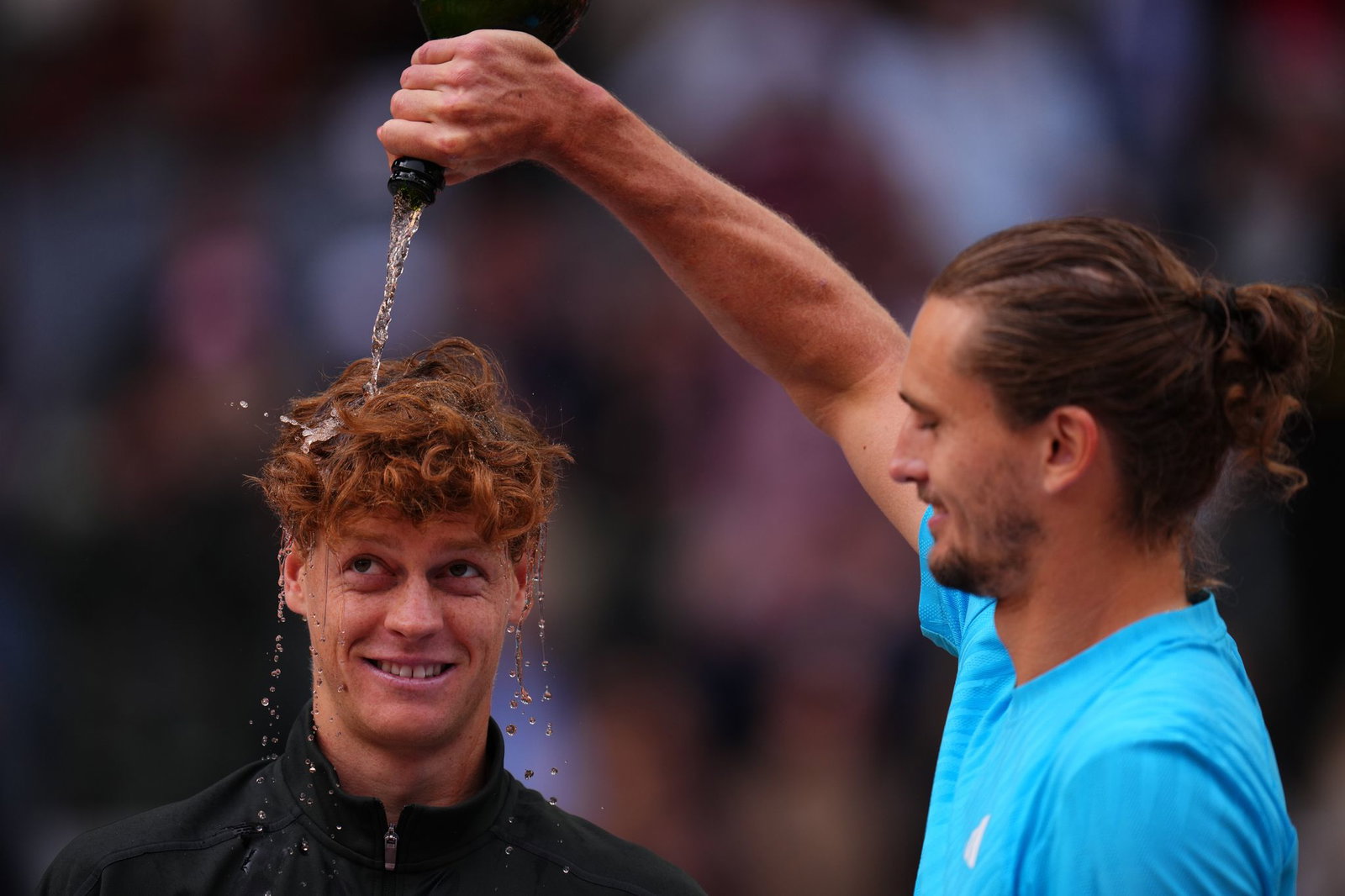 Zverev begießt Sinner mit Champagner. 