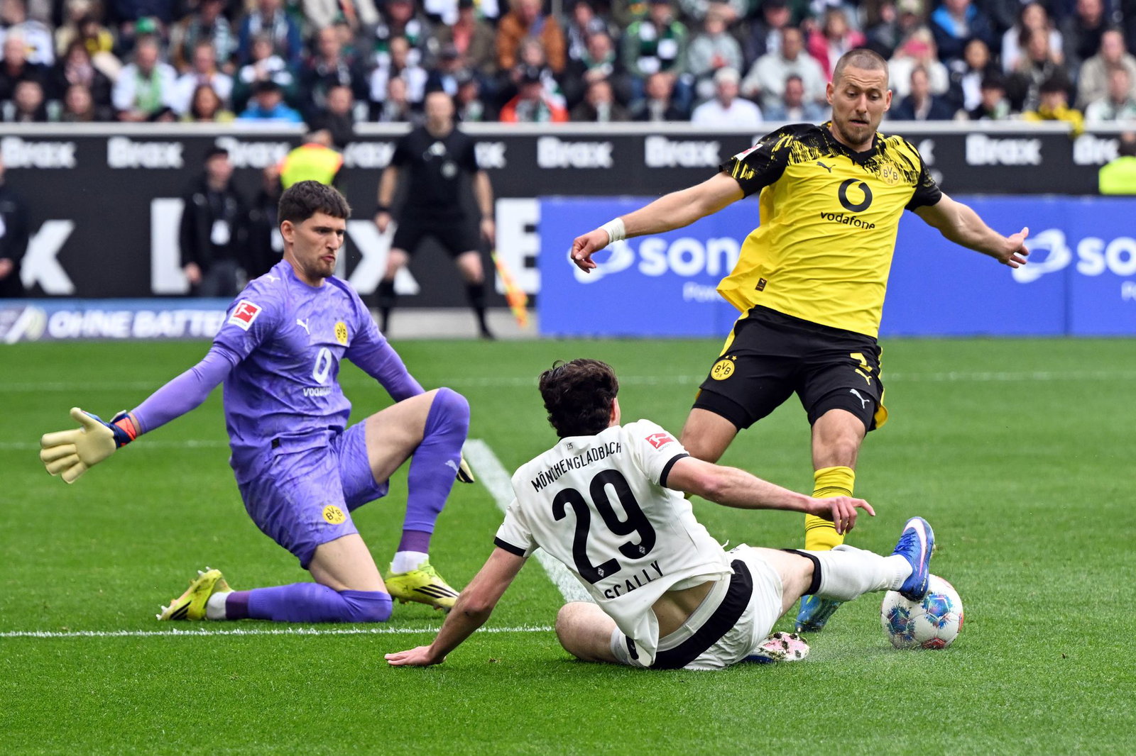 BVB-Torwart Gregor Kobel (l) und Waldemat Anton (r) im Duell mit Gladbachs Joe Scally. 