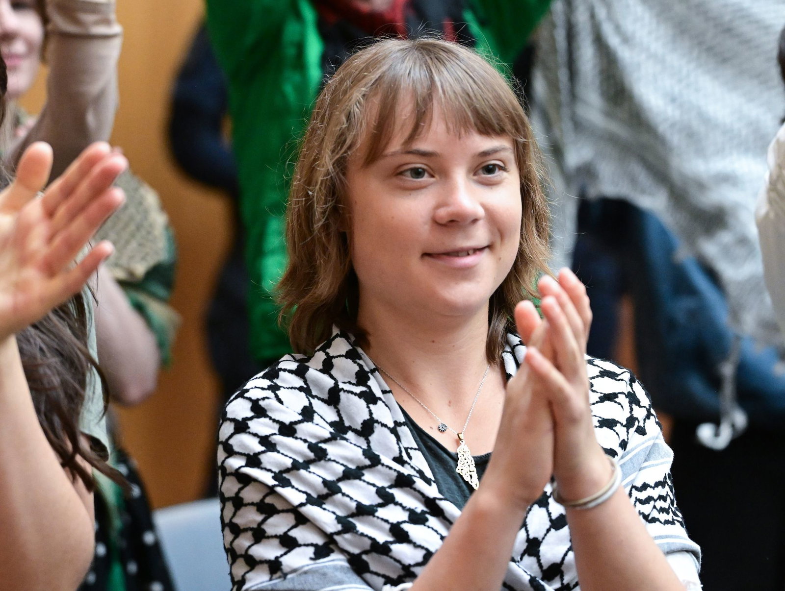 Die Klimaaktivistin Greta Thunberg klatscht als Zuschauerin in einem Gerichtssaal in Stuttgart-Stammheim.