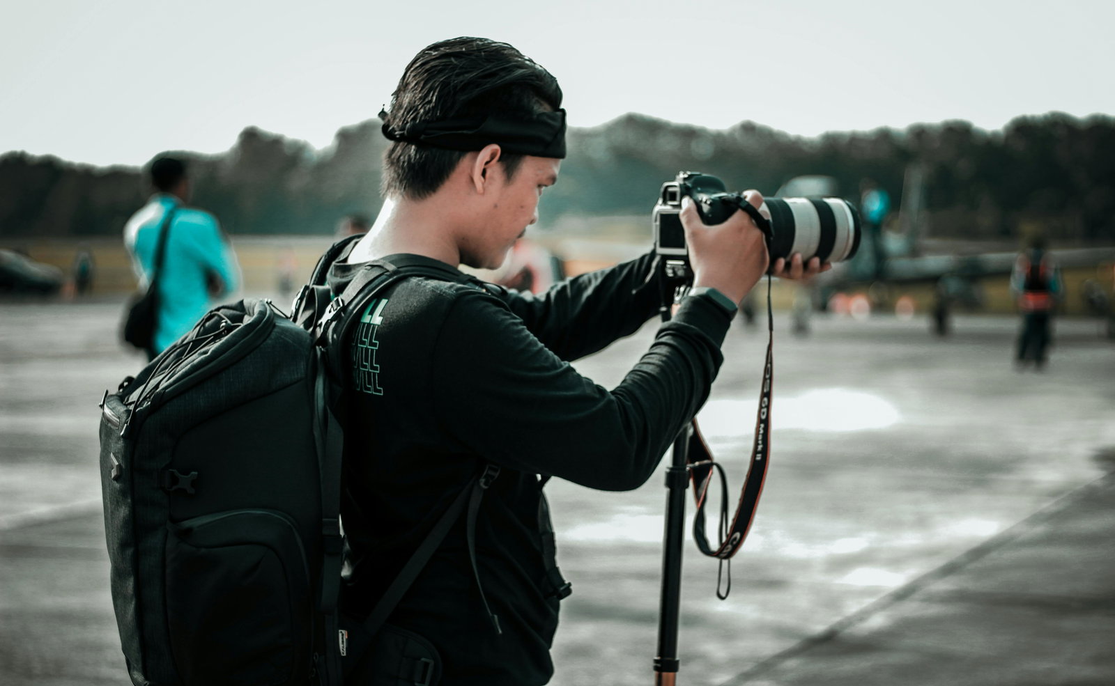 Fotograf trägt Rucksack und macht Foto an der frischen Luft