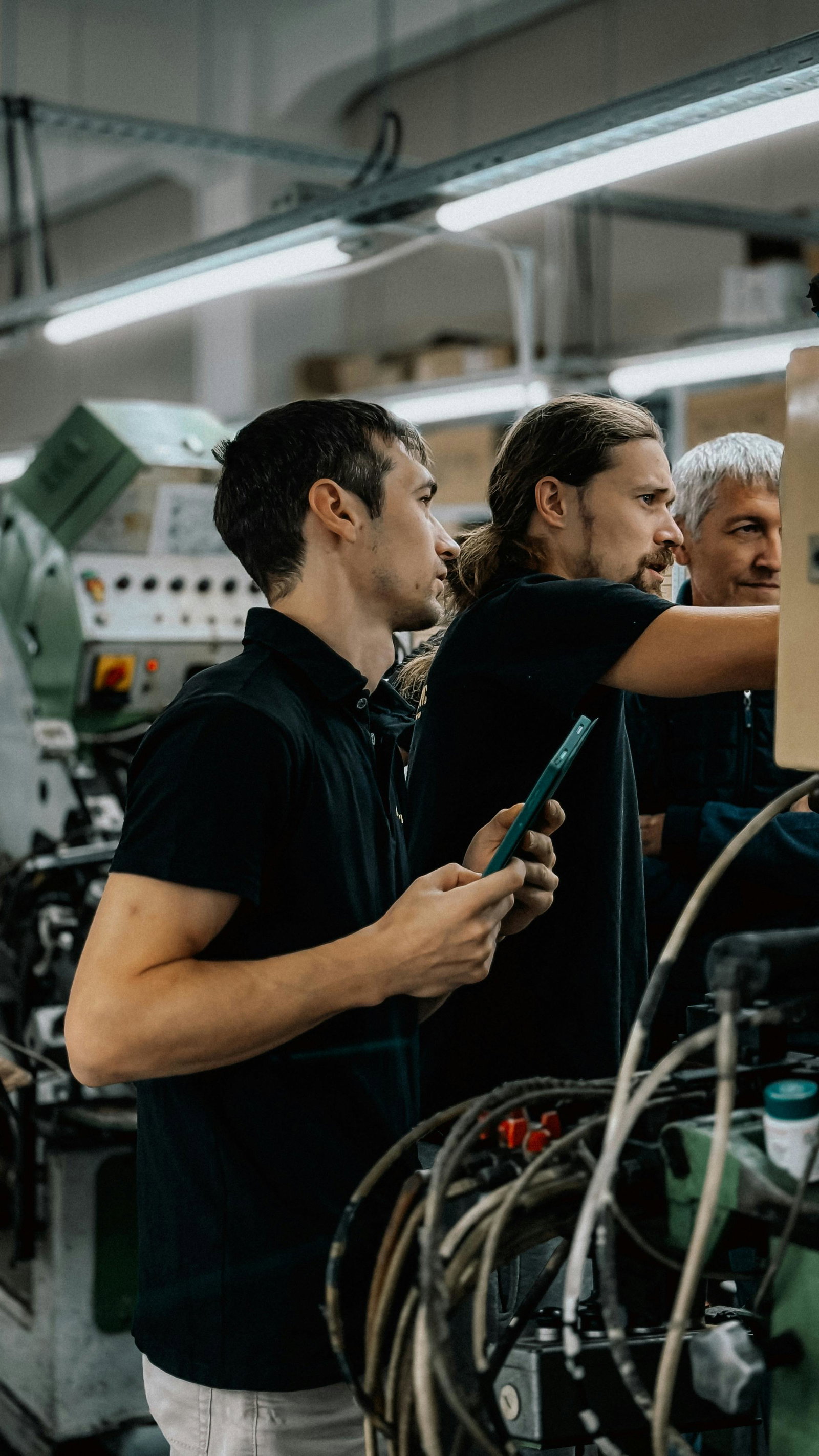 Werkzeugmechaniker stehen mit Tablet vor Maschine