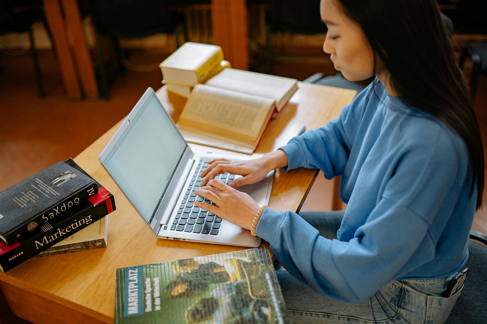 Studentin sitzt in der Bib am Laptop und schreibt ihre Bachelorarbeit 