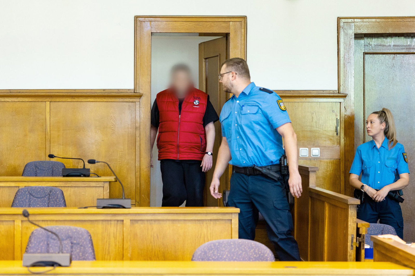 Der Angeklagte wird von Justizvollzugsbeamten in den Saal 38 des Landgerichts Saarbrücken geführt.