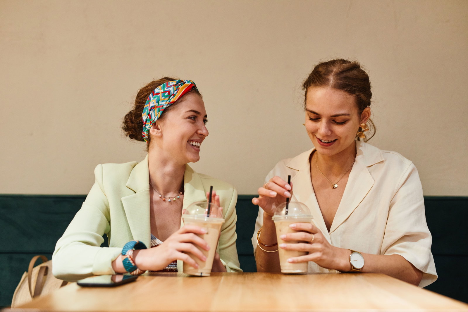 Zwei lachende Frauen am Kaffee trinken