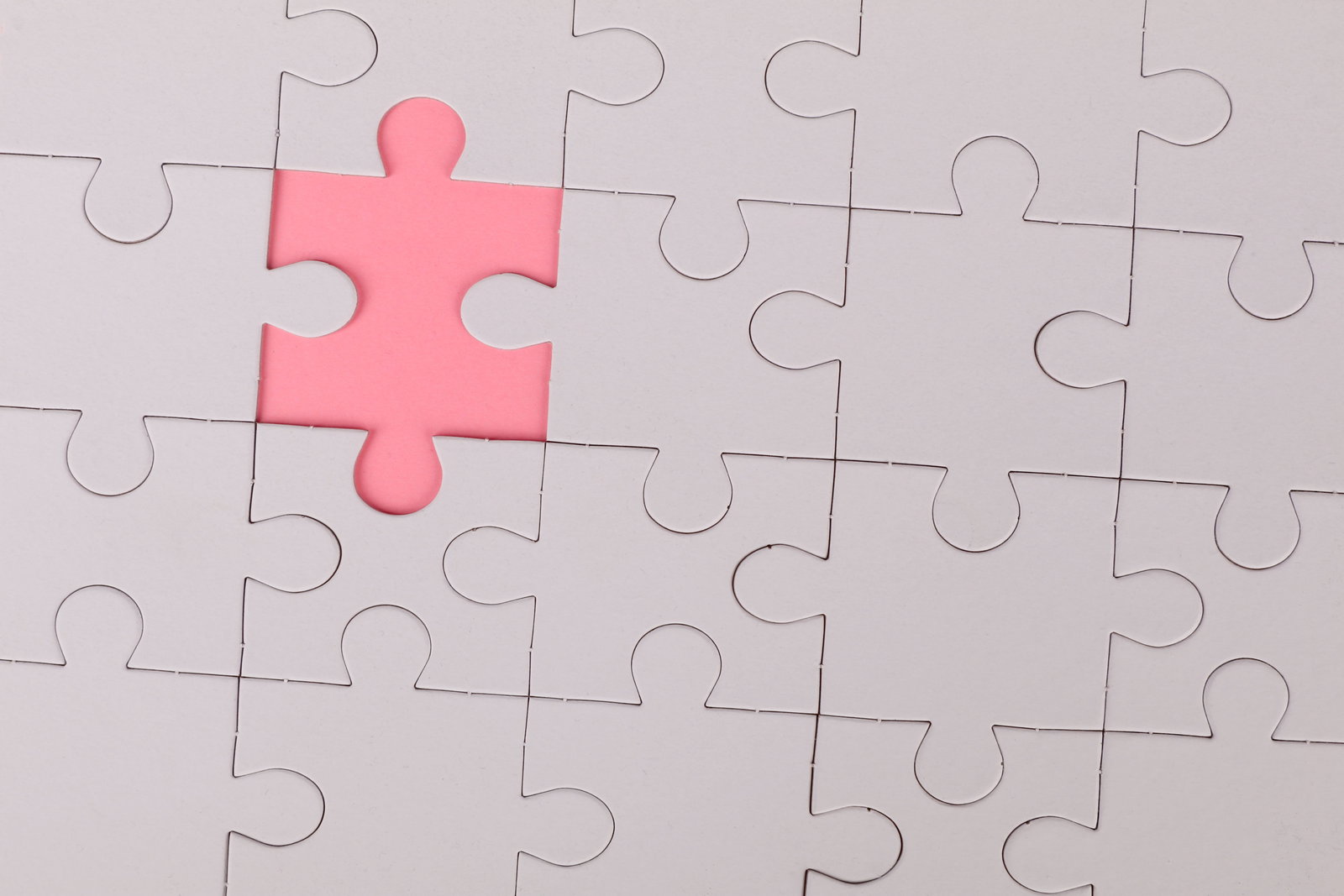 Graues Puzzle mit einem fejlenden Teil, Untergrund ist pink