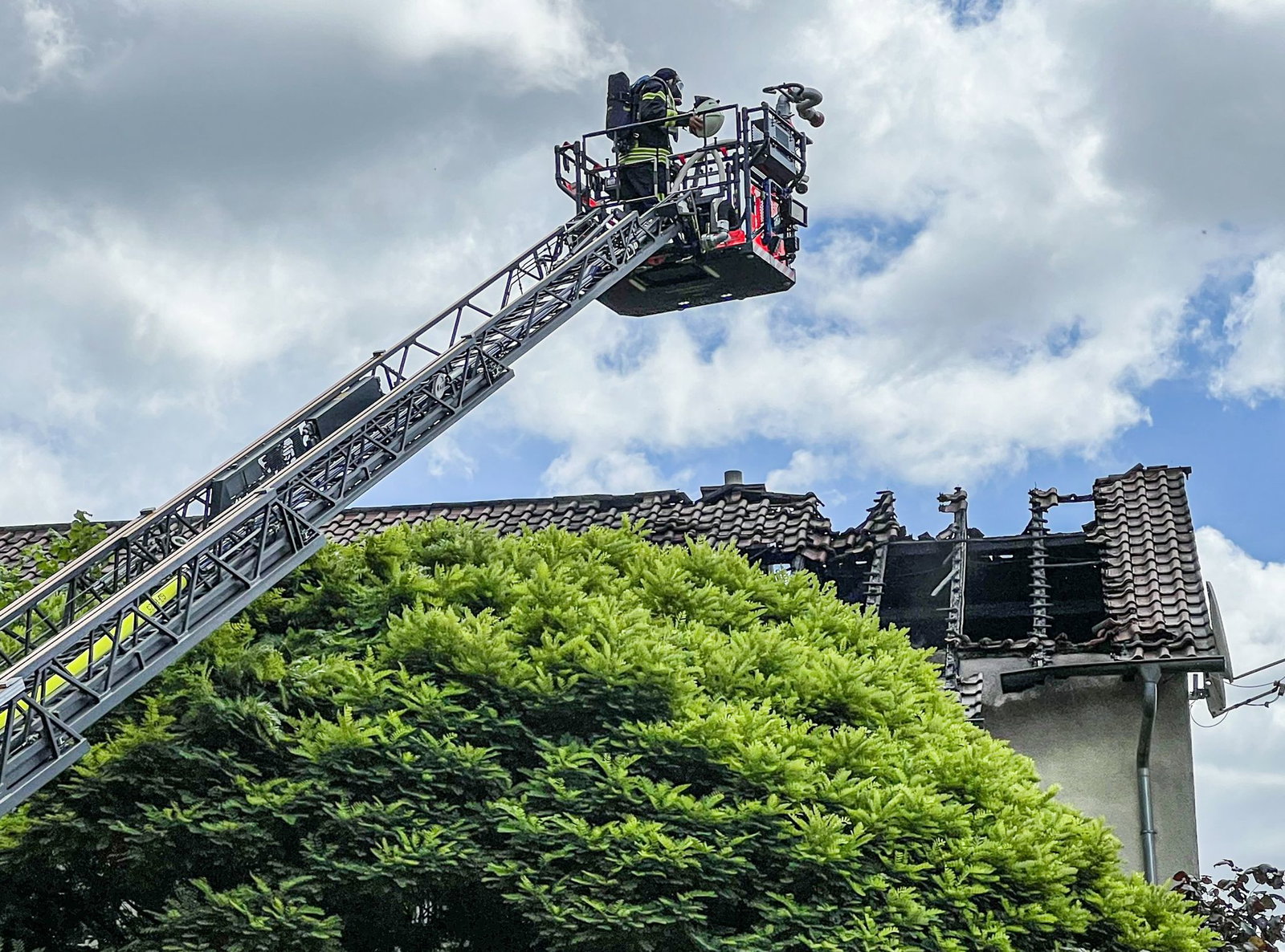 Die Löscharbeiten der Feuerwehr am Dachstuhl laufen. 