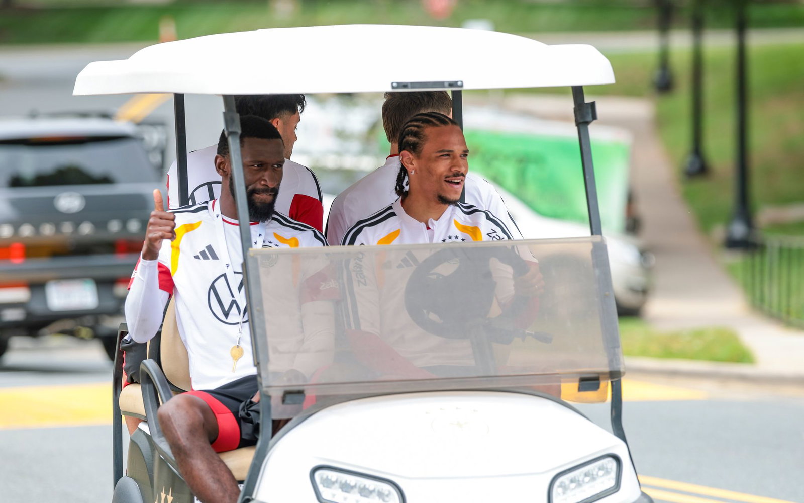 Zwei Umstrittene, die sich bestens verstehen: Beifahrer Antonio Rüdiger und Fahrer Leroy Sané (r) im Golfcart auf dem Weg zum Trainingsplatz. (Archivbild)  