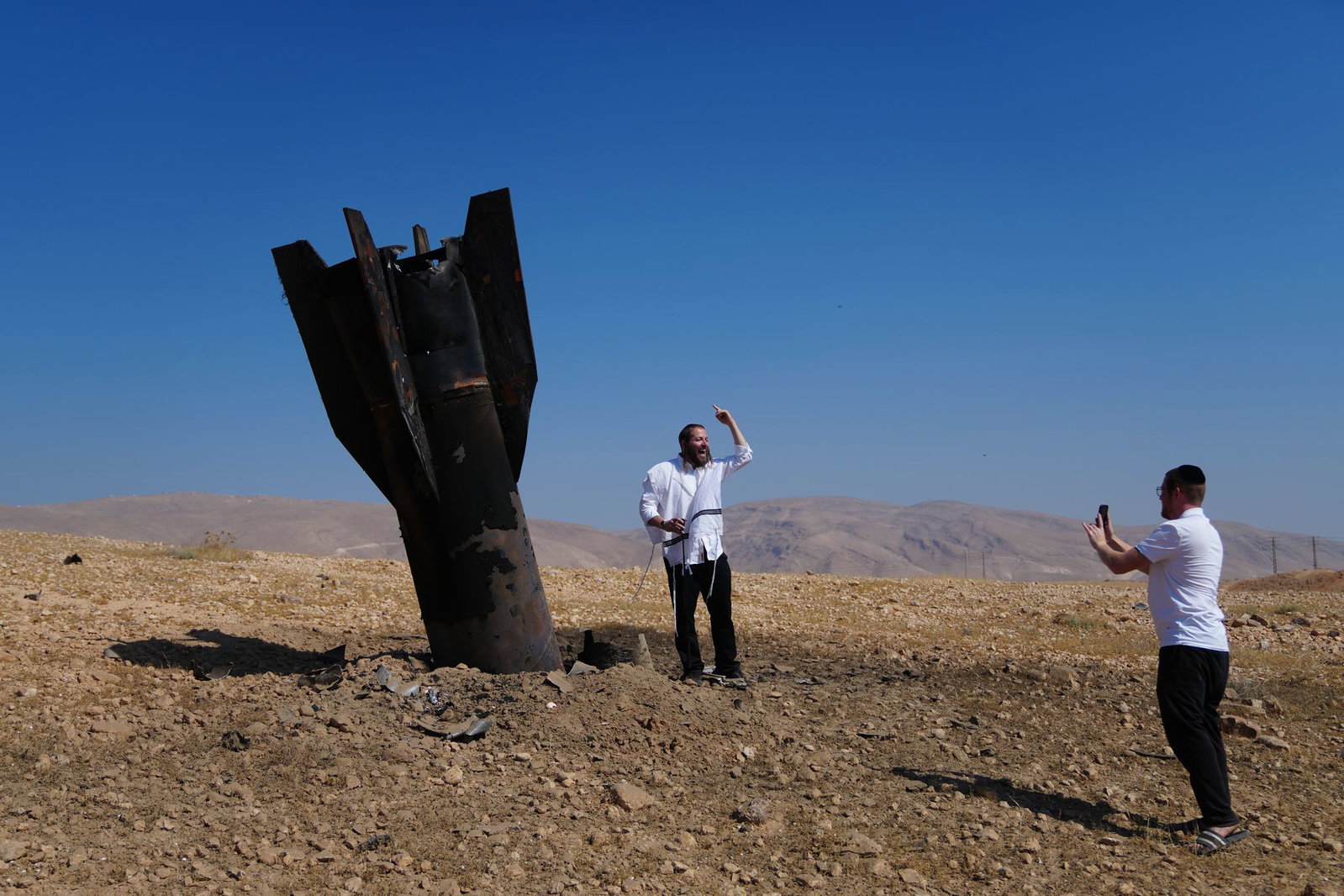 Menschen neben dem Wrack einer iranischen Rakete, die im Westjordanland eingeschlagen ist. 