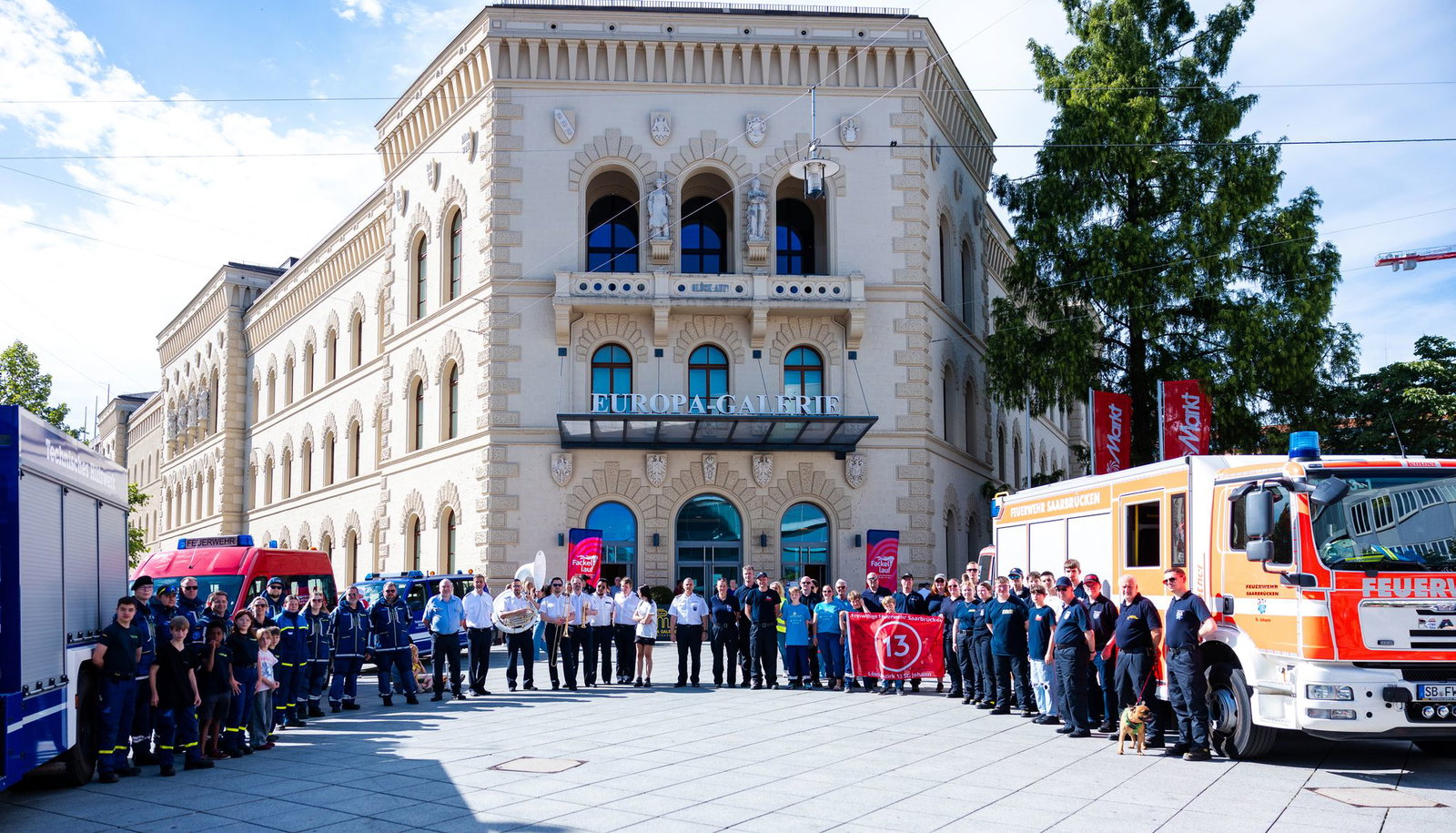 Vor der EUROPA-Galerie haben sich Einsatzkräfte des THW, der Freiwilligen Feuerwehr Saarbrücken-Alt-Saarbrücken (LB 11) und Saarbrücken-St. Johann (LB 13) sowie die Big Band der Polizei des Saarlandes versammelt.