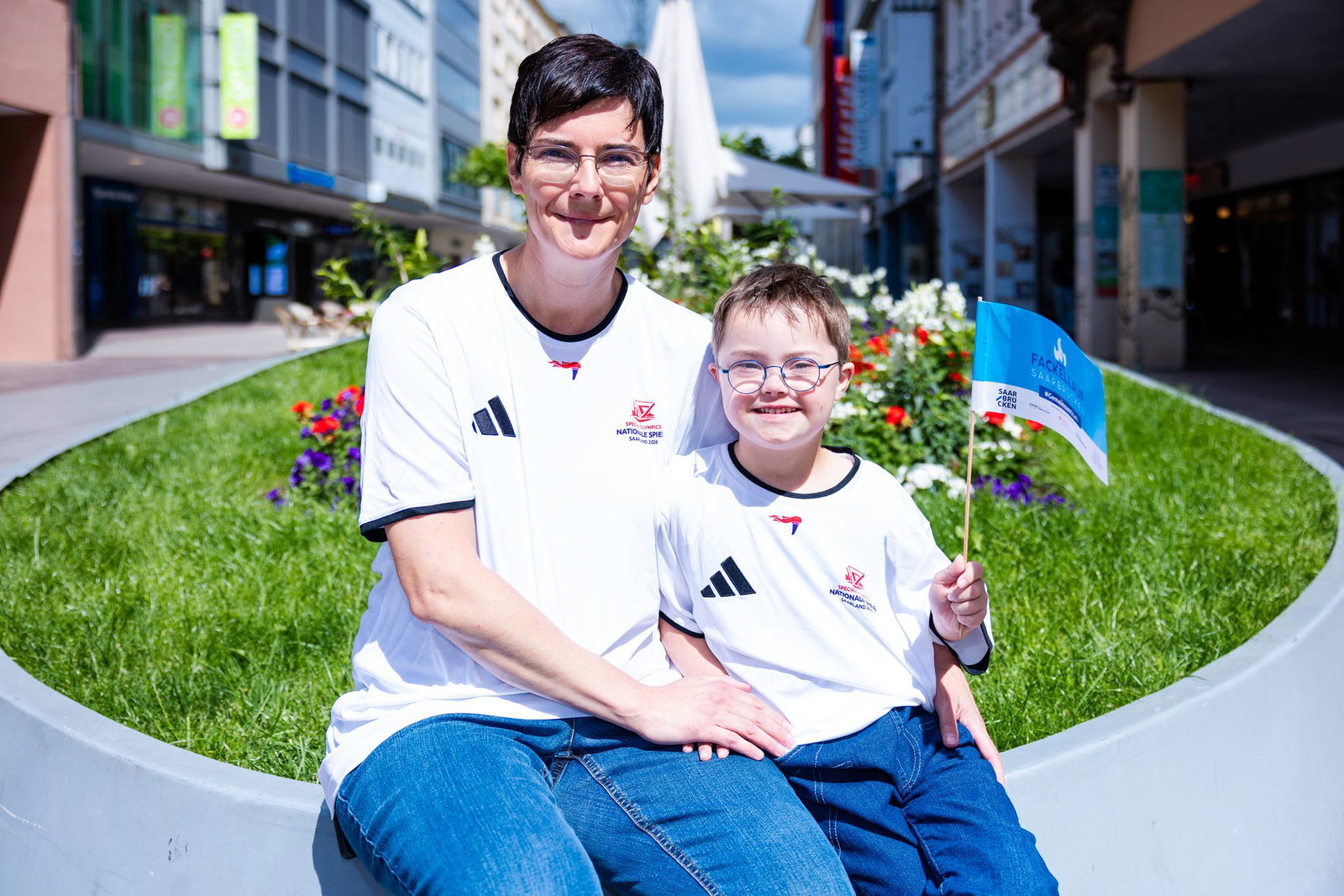 Der achtjährige Elias steht zusammen mit seiner Mutter in der Saarbrücker Bahnhofstraße kurz vor seinem großen Auftritt beim Fackellauf der Special Olympics.