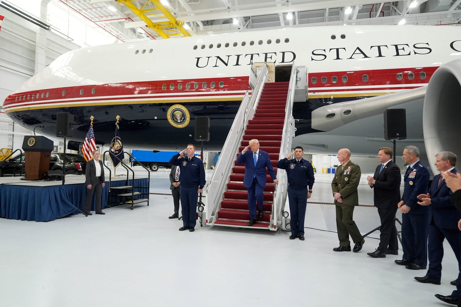Trump salutiert auf der Gangway des geschenkten Flugzeugs.