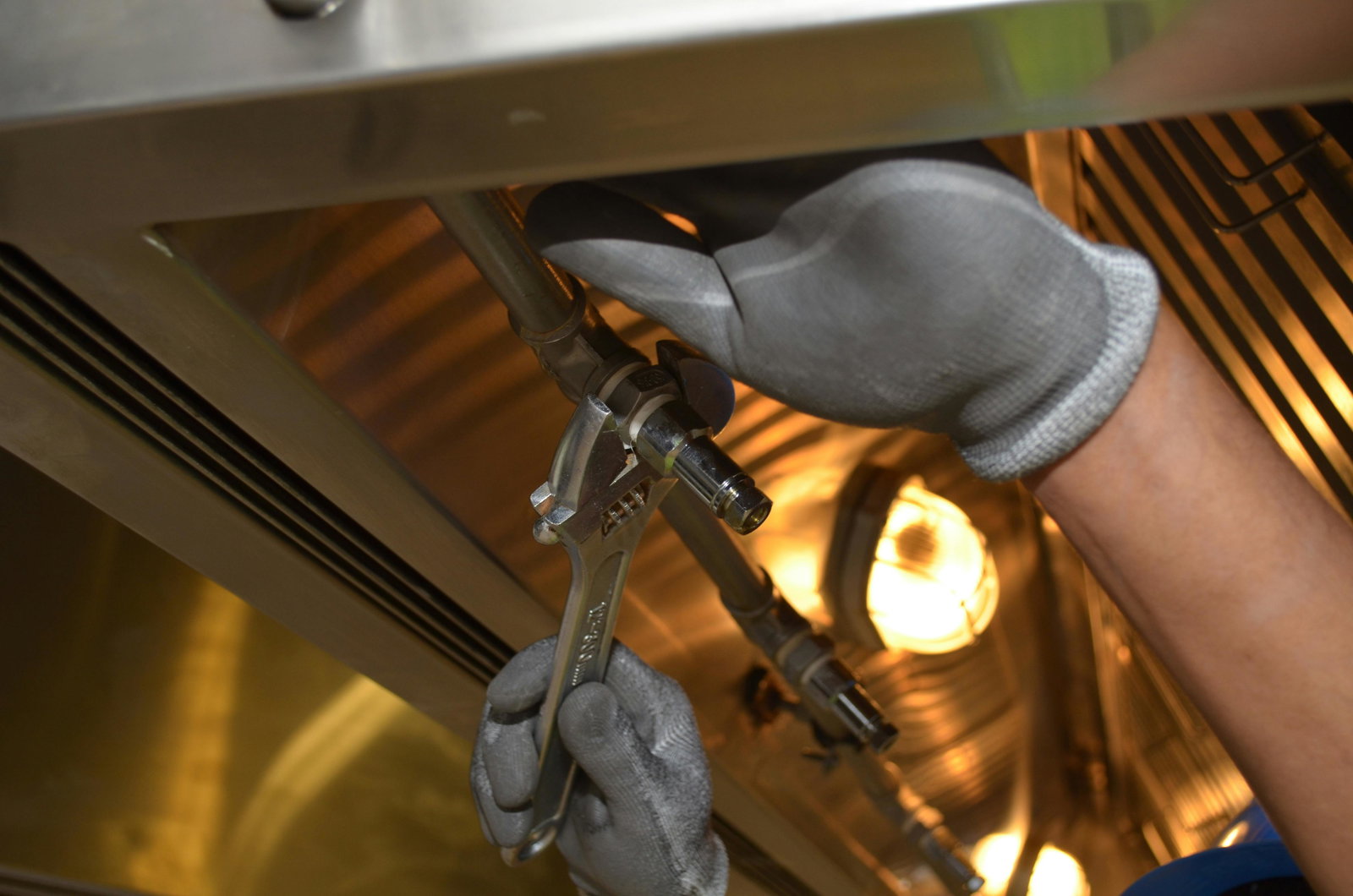 Klempner arbeitet mit Maschine und trägt Handschuhe