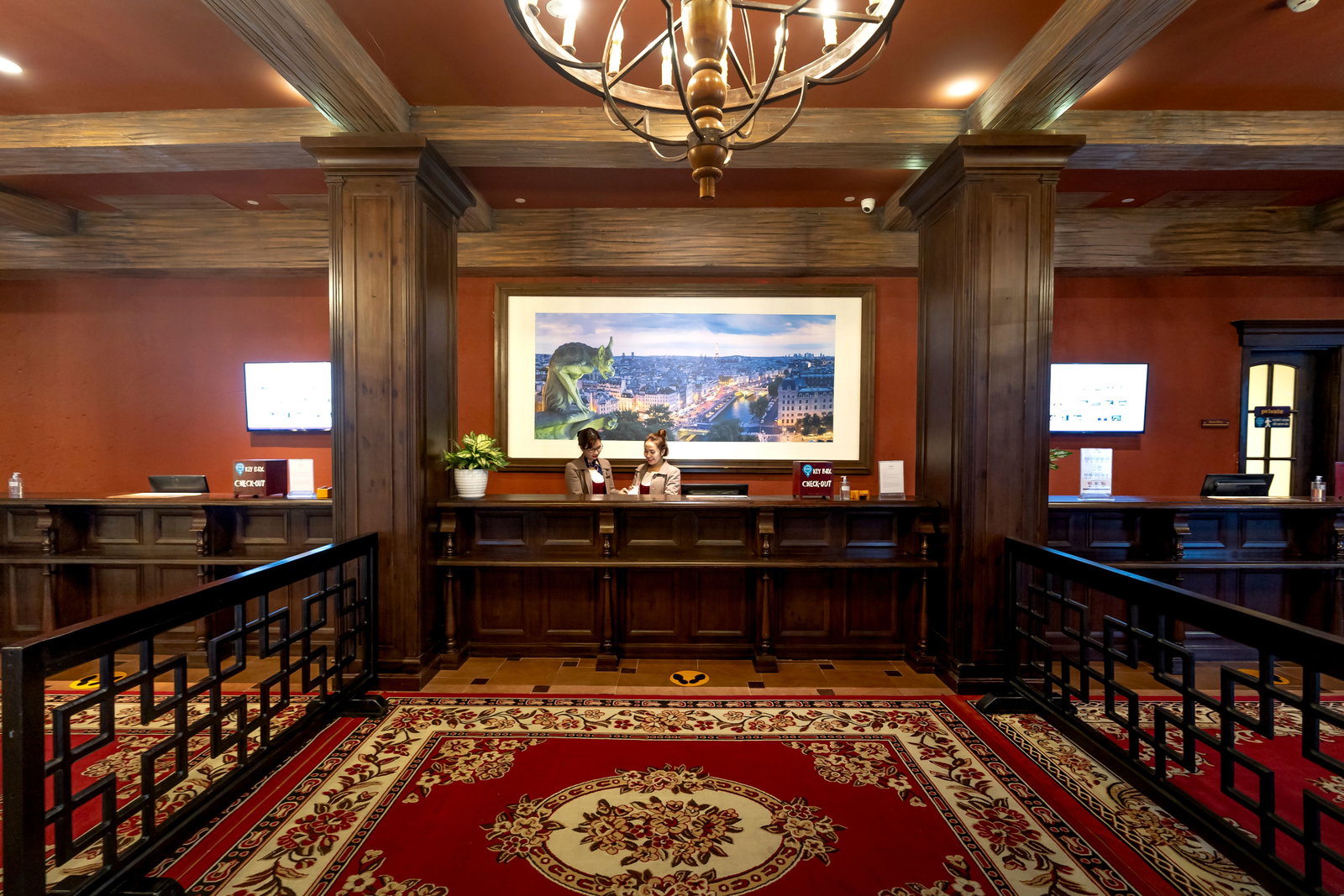 Hotelangestellte stehen an der Rezeption in der Lobby und reden miteinander 