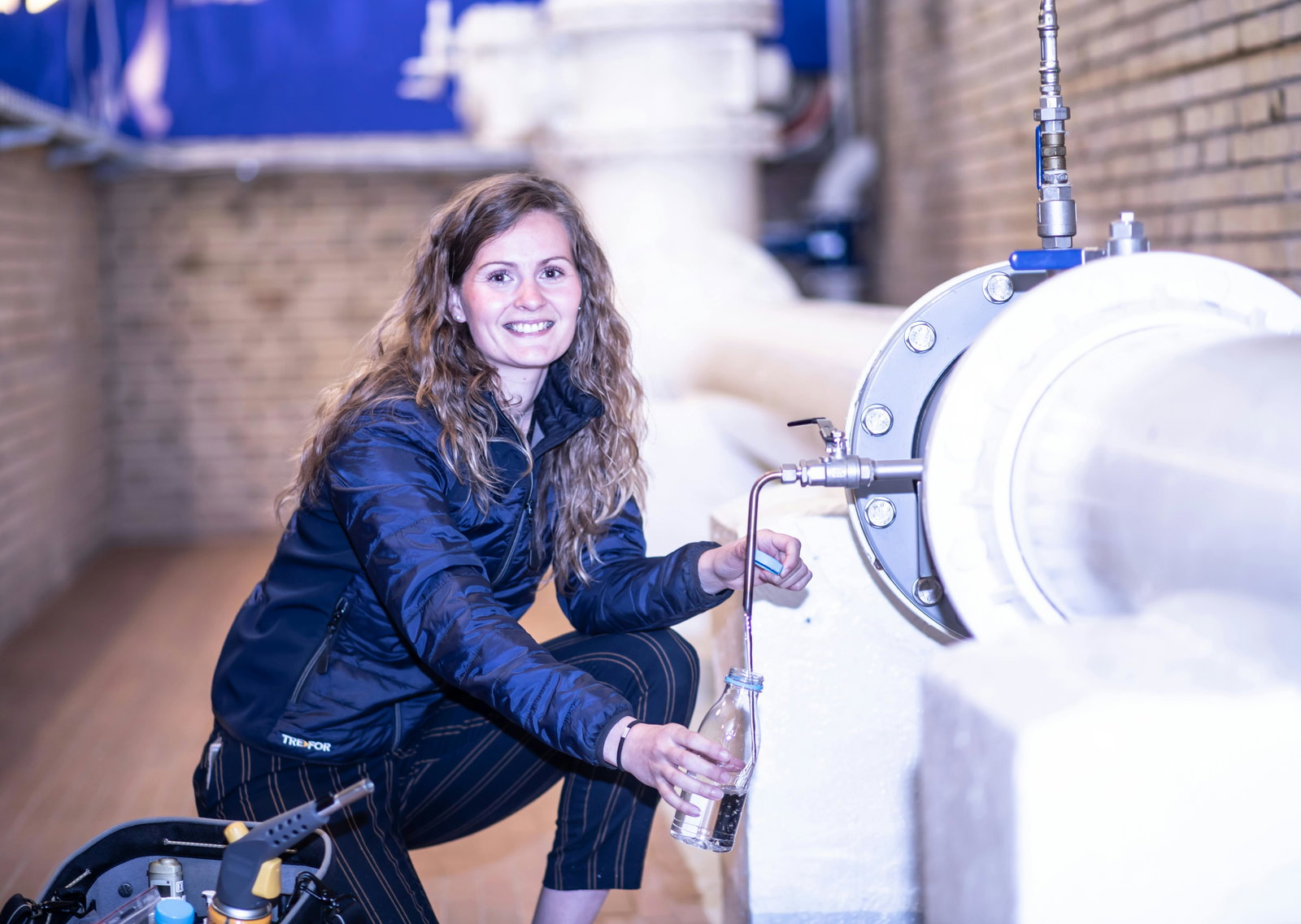 Klempnerin arbeitet an einer Abwasseranlage