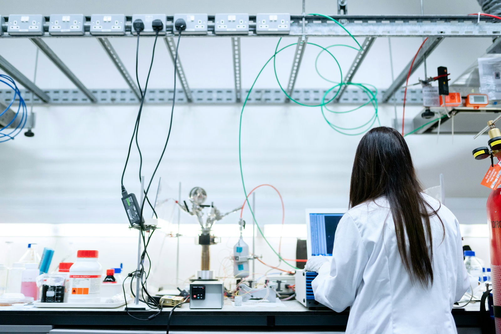 Chemikantin steht an Arbeitsplatz und arbeitet am Computer