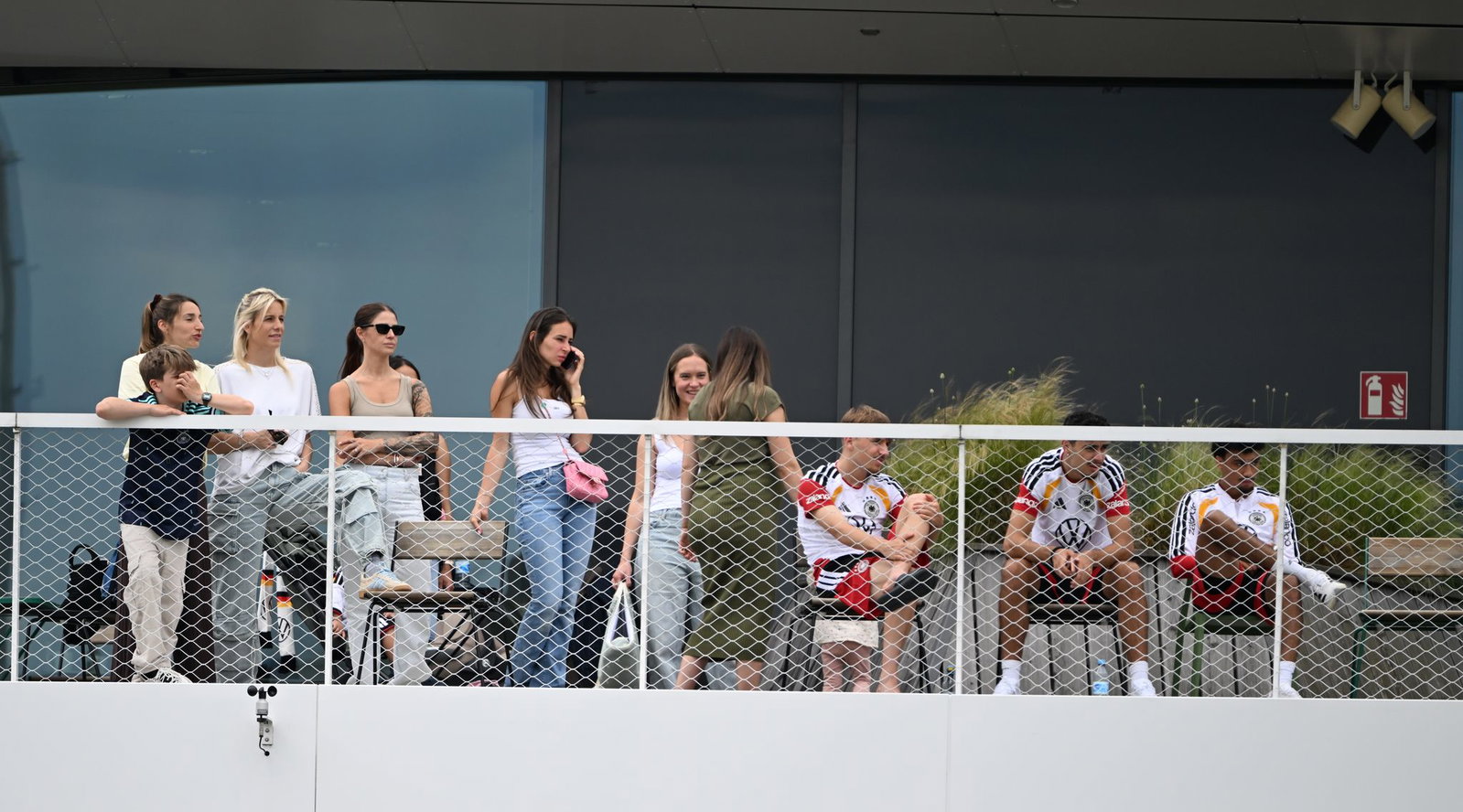 Einige Spielerfrauen und die Frau des Bundestrainers (l) beobachten von einem Balkon das Trainingsspiel der Reservisten auf dem DFB-Campus. 