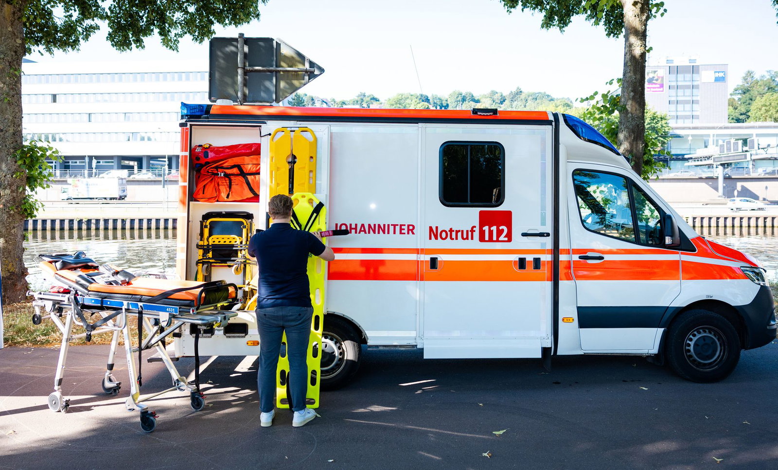 Ein Mitarbeiter der Johanniter-Unfall-Hilfe bereitet eine Station neben einem Rettungswagen vor.