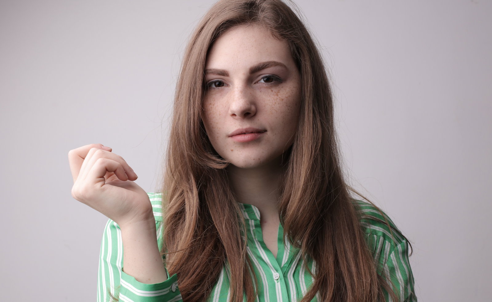 Frau in grün gestreifter Bluse und Hand