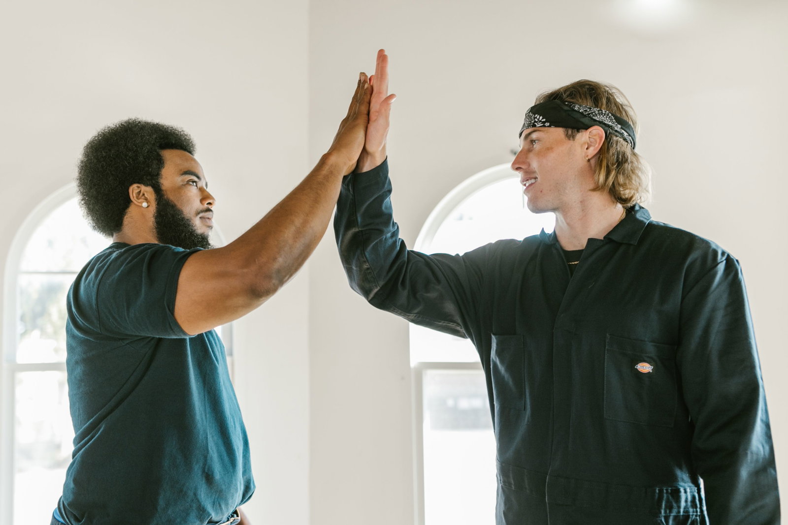 zwei Menschen geben sich high five und schauen sich an 