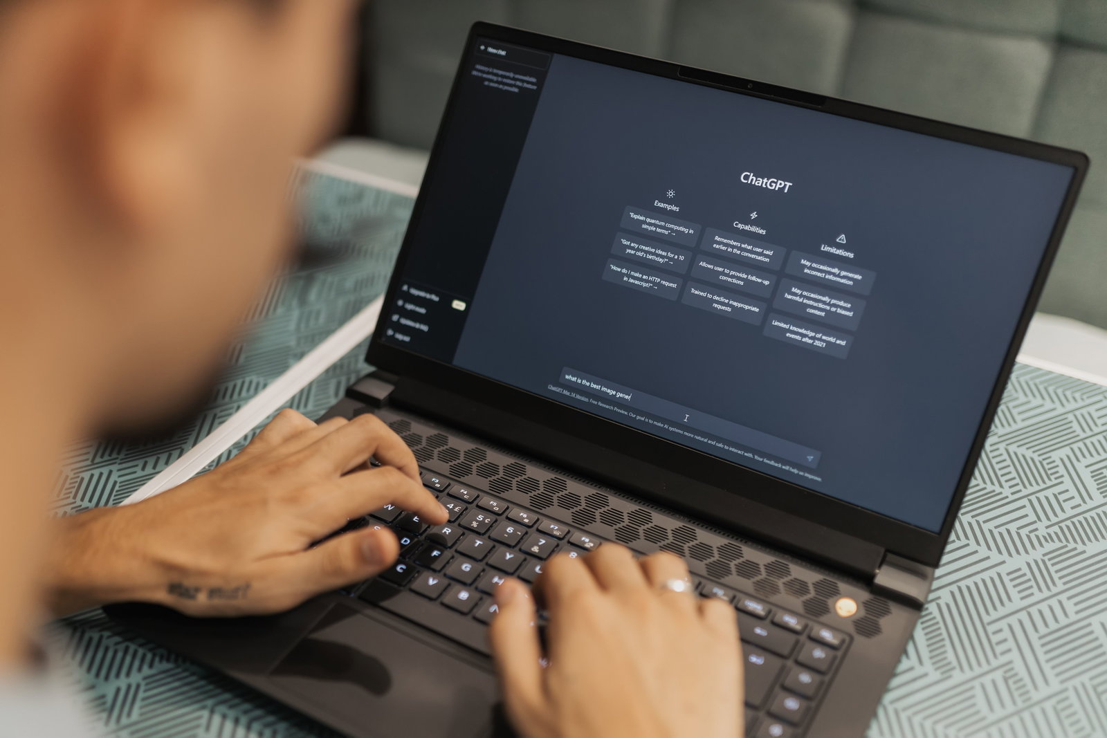 Person am Laptop und schreibt etwas in ChatGPT