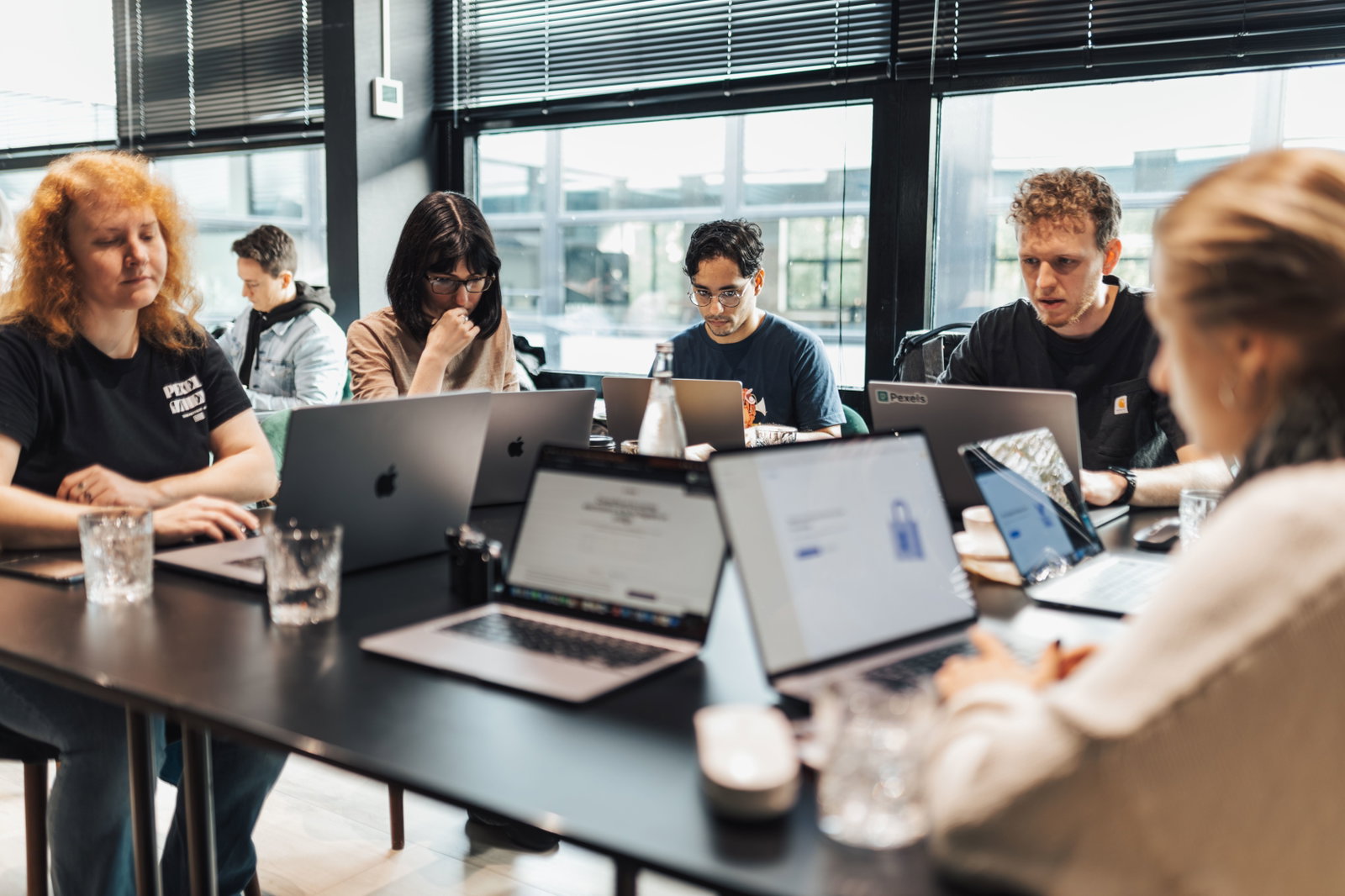 Gruppe schreibt am Laptop und sitzt am Tisch