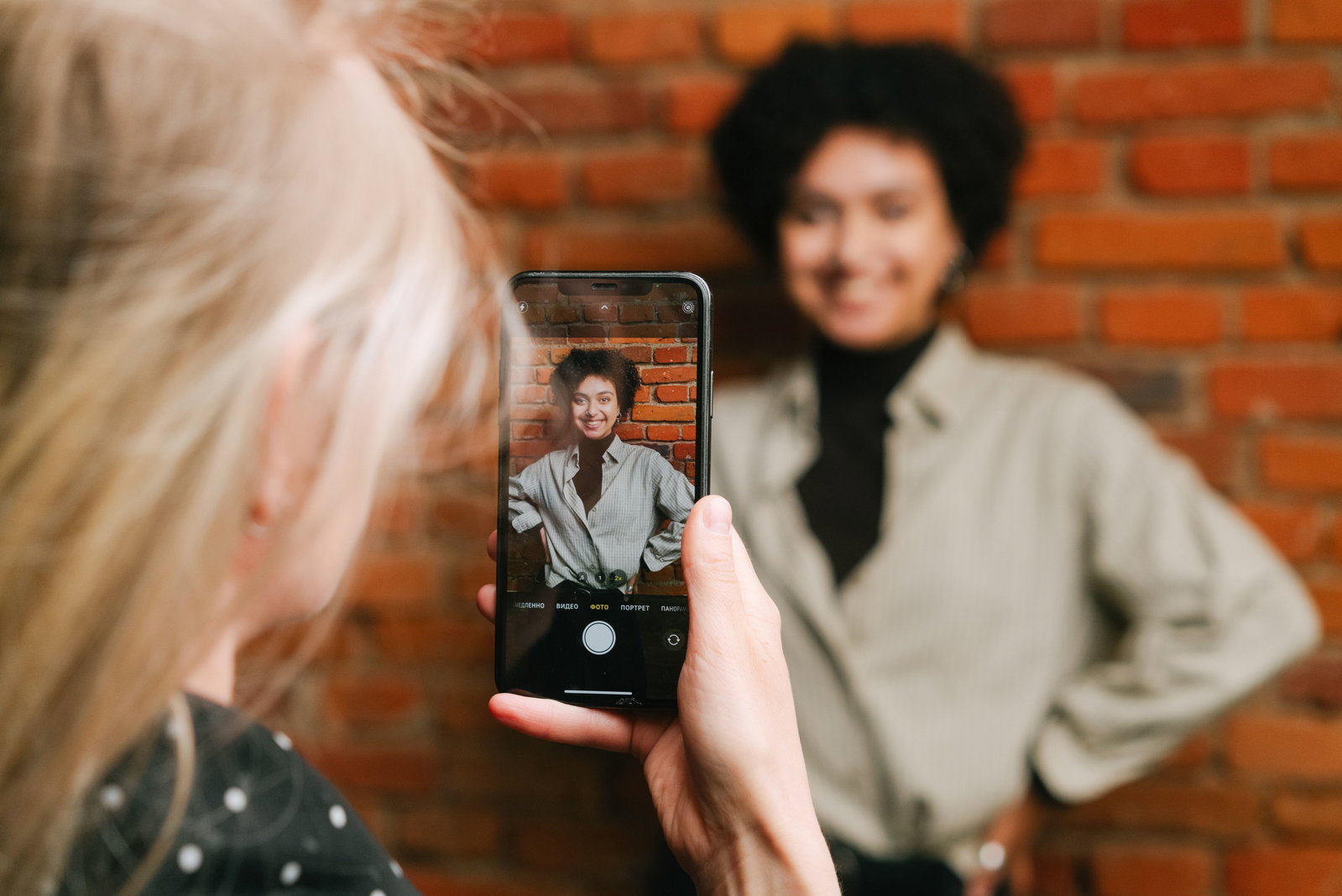 Mädchen mit Handy macht Bild von einem anderen Mädchen