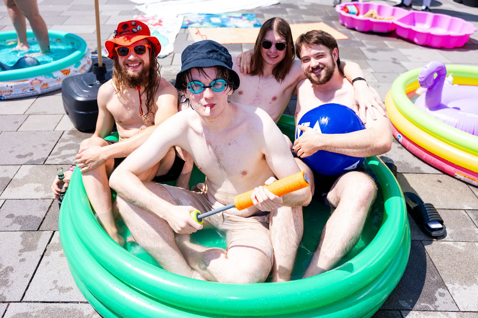 Vier Studierende sitzen in einem grünen aufblasbaren Pool vor Gebäude 10 der HTW.