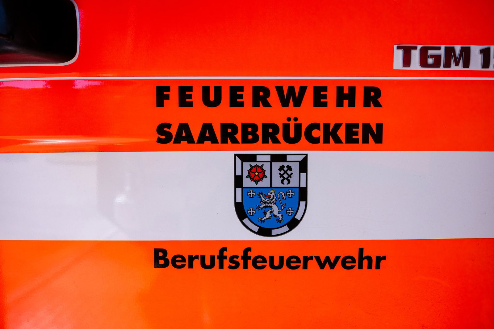 Auf der Fahrzeugtür eines Löschfahrzeugs sind das Saarland-Wappen und der Schriftzug «Feuerwehr Saarbrücken – Berufsfeuerwehr» zu sehen.
