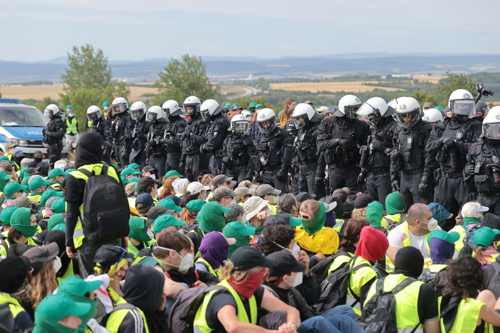 Eine Sitzblockade auf der Autobahn 71 - Polizisten umringen die Demonstranten.