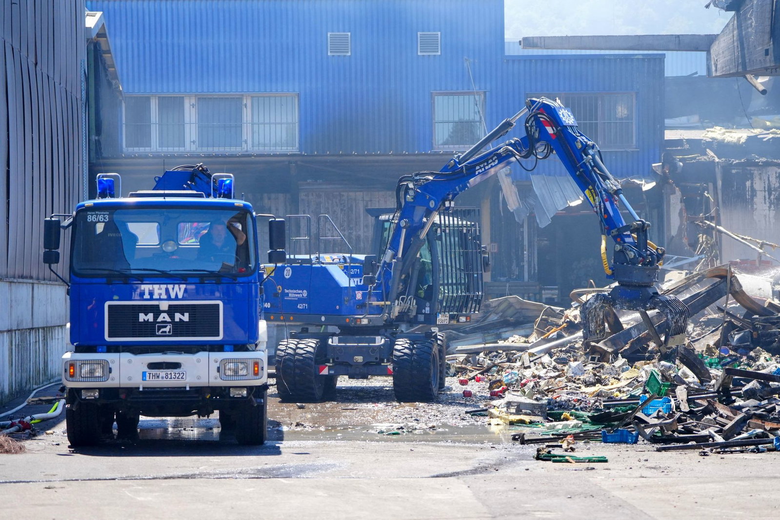 Einsatzkräfte des Technischen Hilfswerks (THW) beseitigen mit einem Bagger Schutt nach einem Feuer in einem Gewerbegebiet in Stuttgart. (Archivbild)